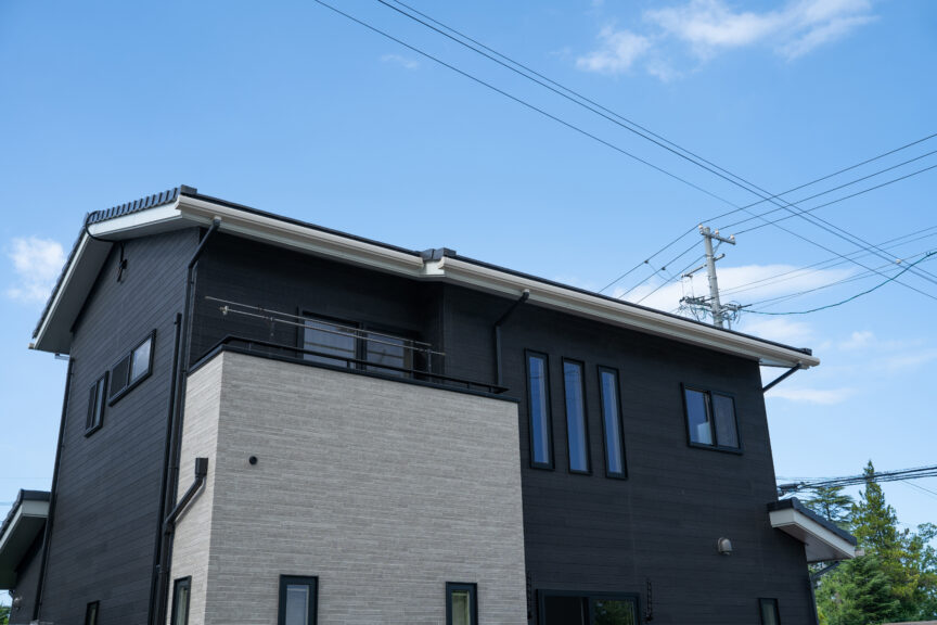 外壁にブラックとグレーのツートンカラーを使用した家の写真