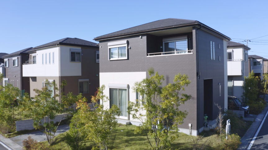 外壁にグレーとホワイトのツートンを使用した家の写真