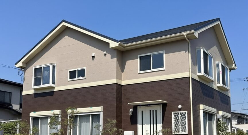 外壁にブラウンとベージュのツートンを使用した家の写真