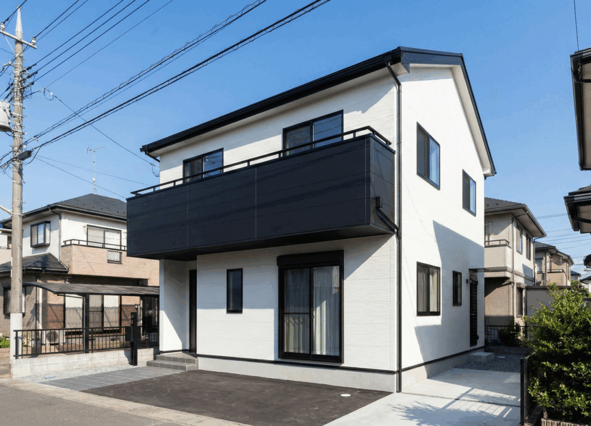 全体は白で、ベランダ部分だけ黒にしたアクセントカラーの家の写真
