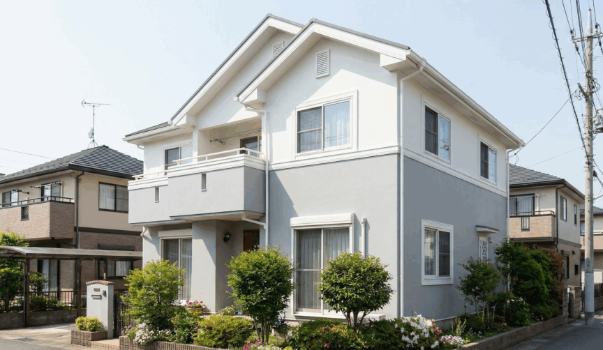ライトグレーと白のツートンカラーを外壁に使用した家の写真