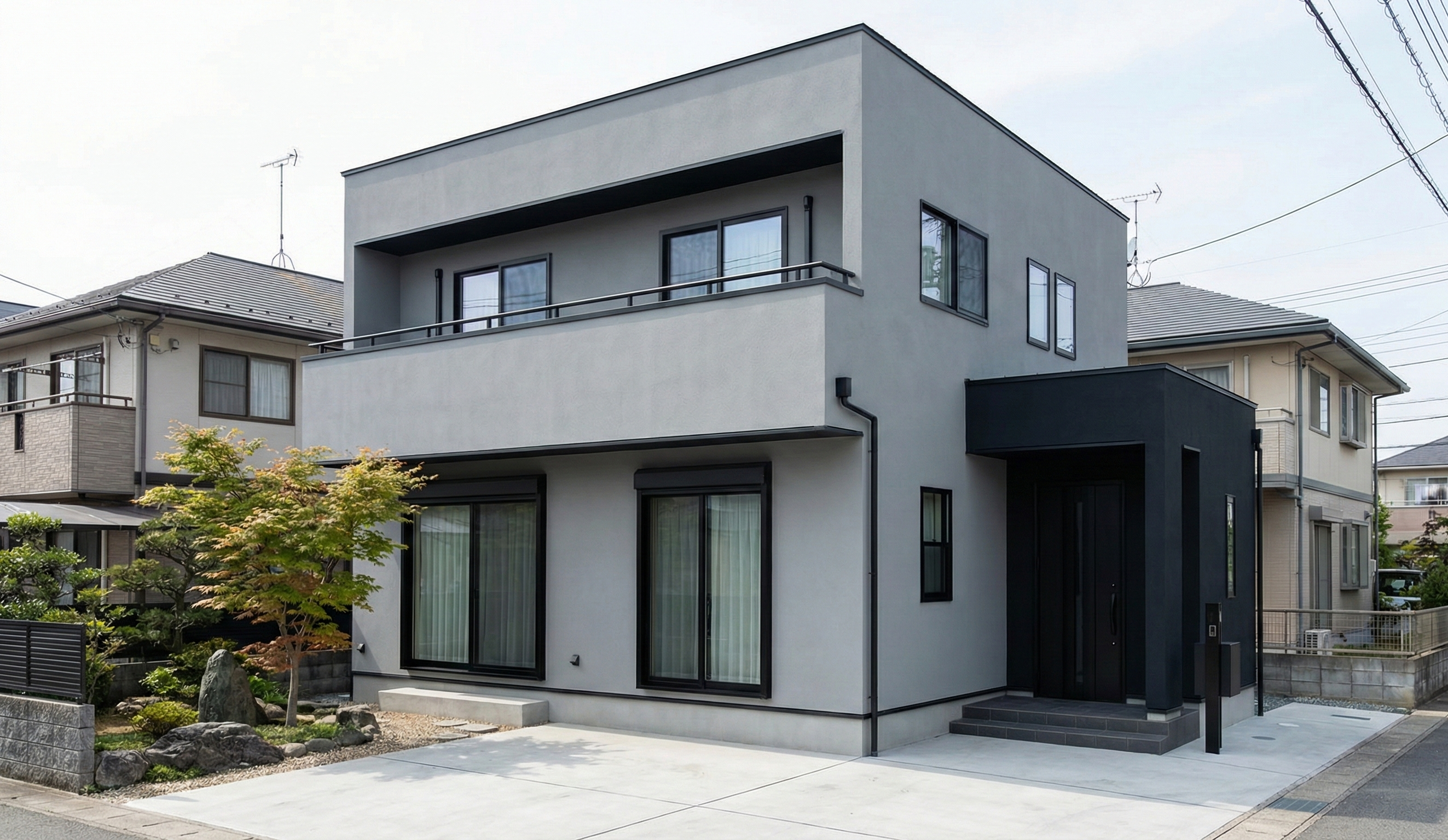 外壁にライトグレーとブラックのツートンカラーを使用した家の写真